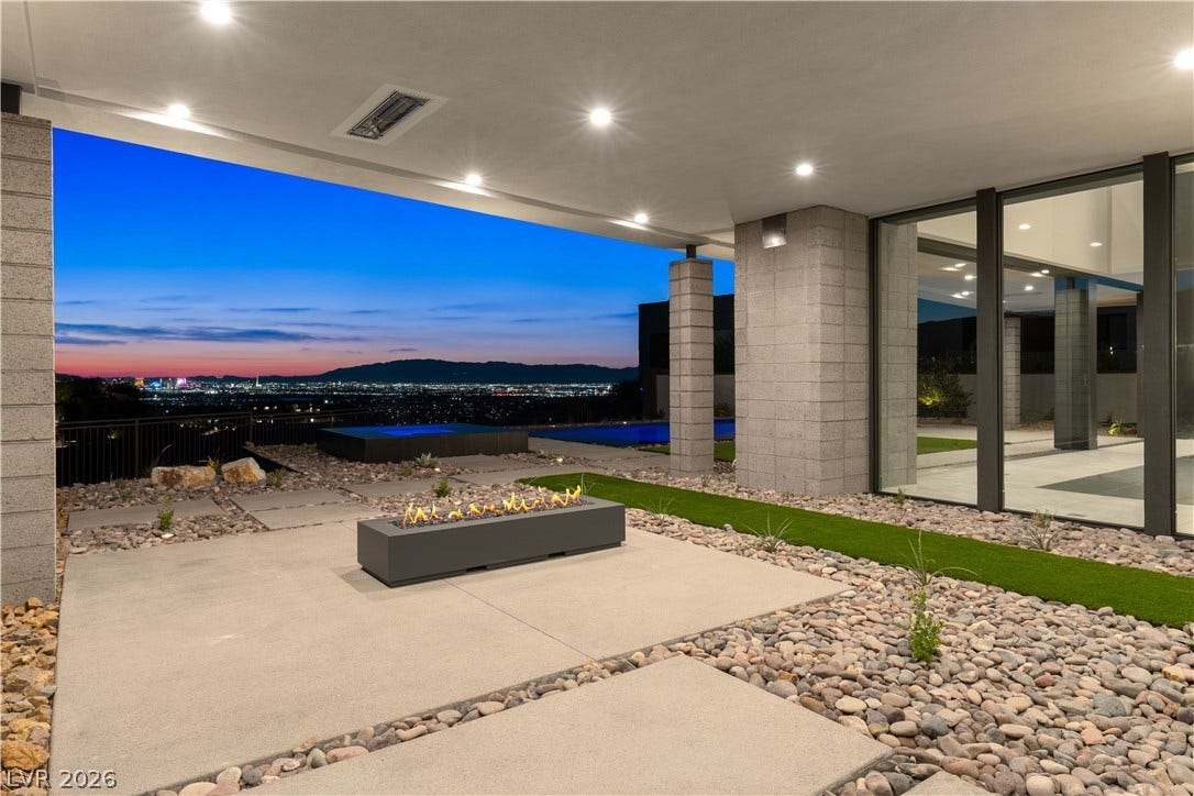 25 Boulderback Drive, Henderson, NV 89012 Panoramic city light views unfold from a modern covered patio with an integrated fire feature.