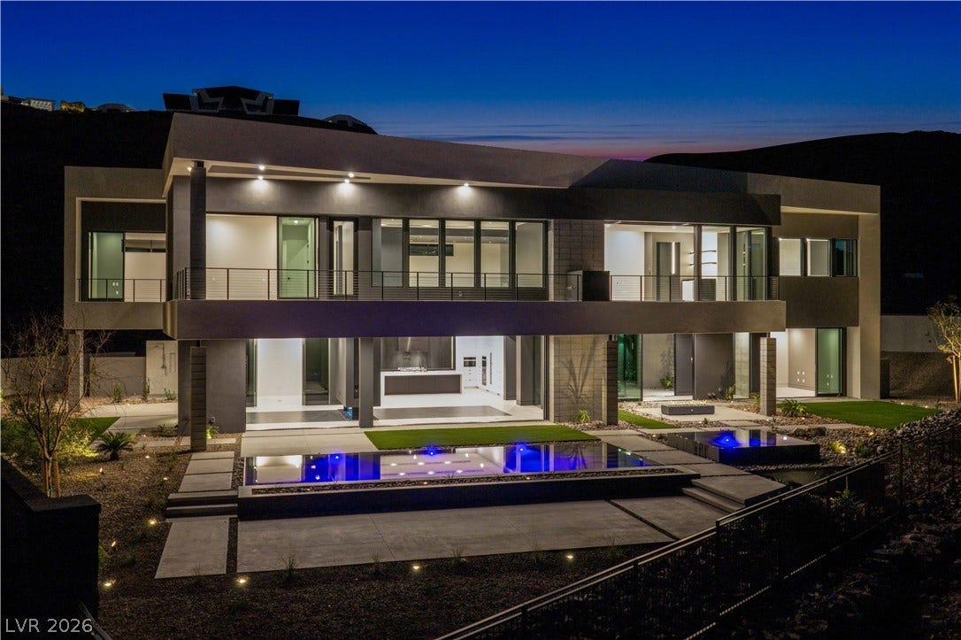 25 Boulderback Drive, Henderson, NV 89012 Striking contemporary architecture integrates seamless indoor-outdoor living spaces alongside a glowing swimming pool.