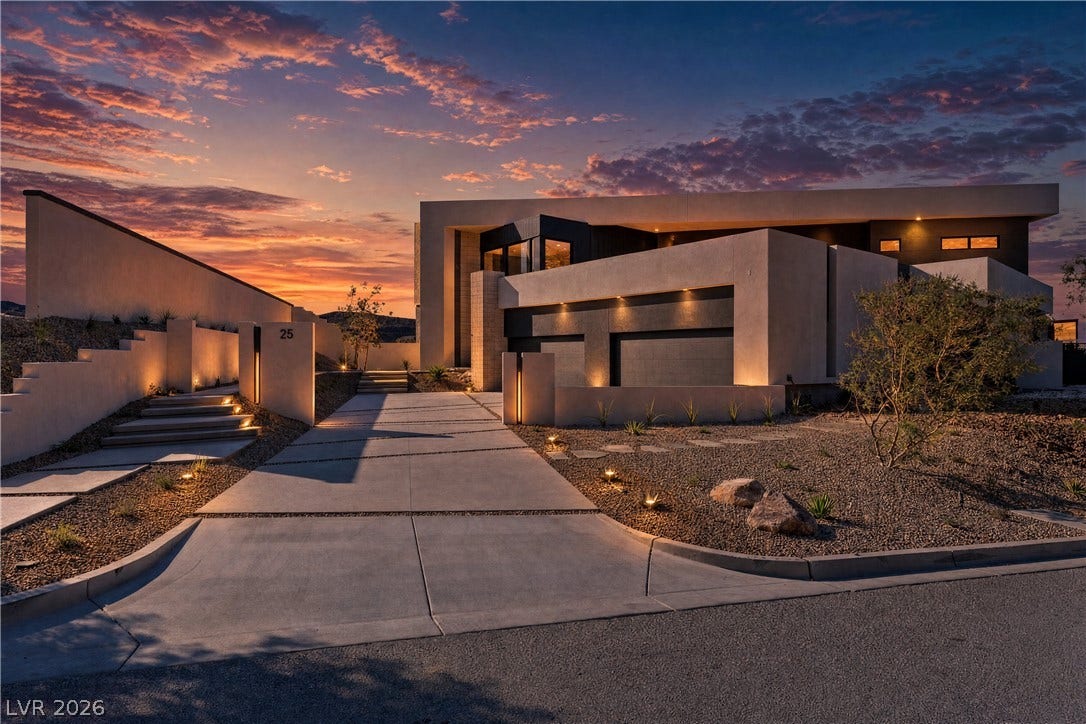 25 Boulderback Drive, Henderson, NV 89012 Dramatic desert architecture framed by custom exterior lighting and an expansive concrete driveway.