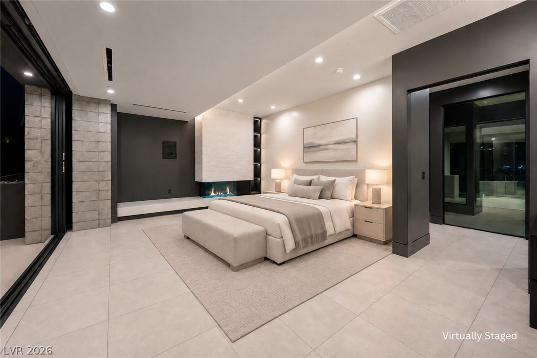 25 Boulderback Drive, Henderson, NV 89012 Recessed lighting and a modern fireplace elevate this bedroom with tile flooring.
