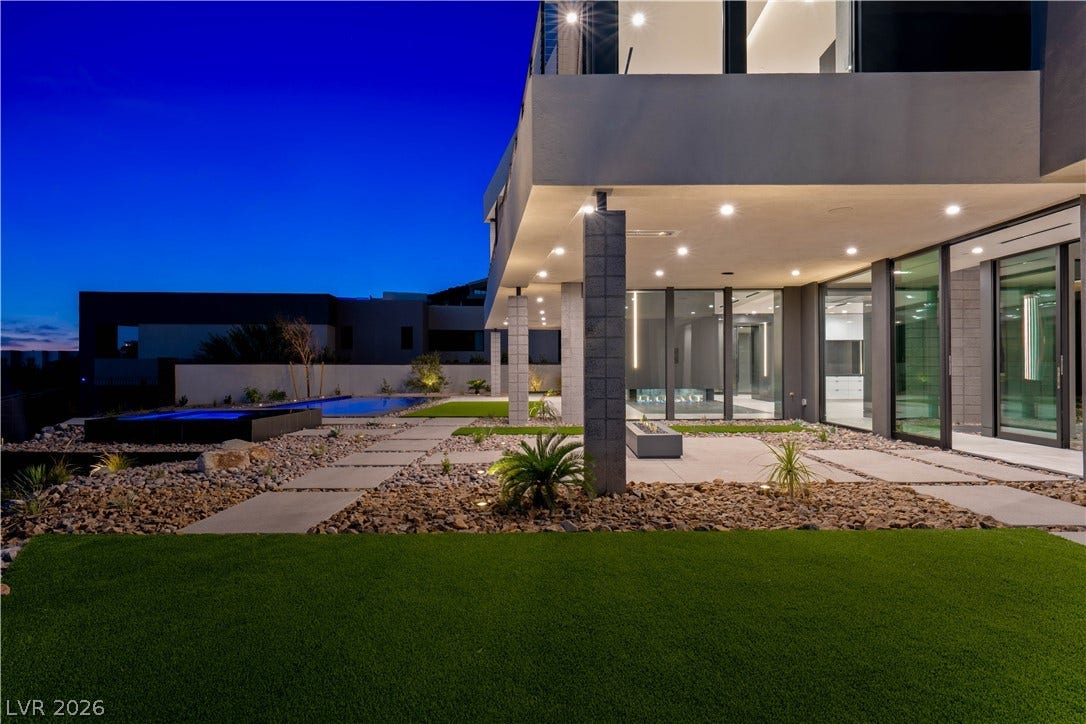 25 Boulderback Drive, Henderson, NV 89012 Recessed lighting illuminates the covered patio area alongside a modern pool under twilight skies.