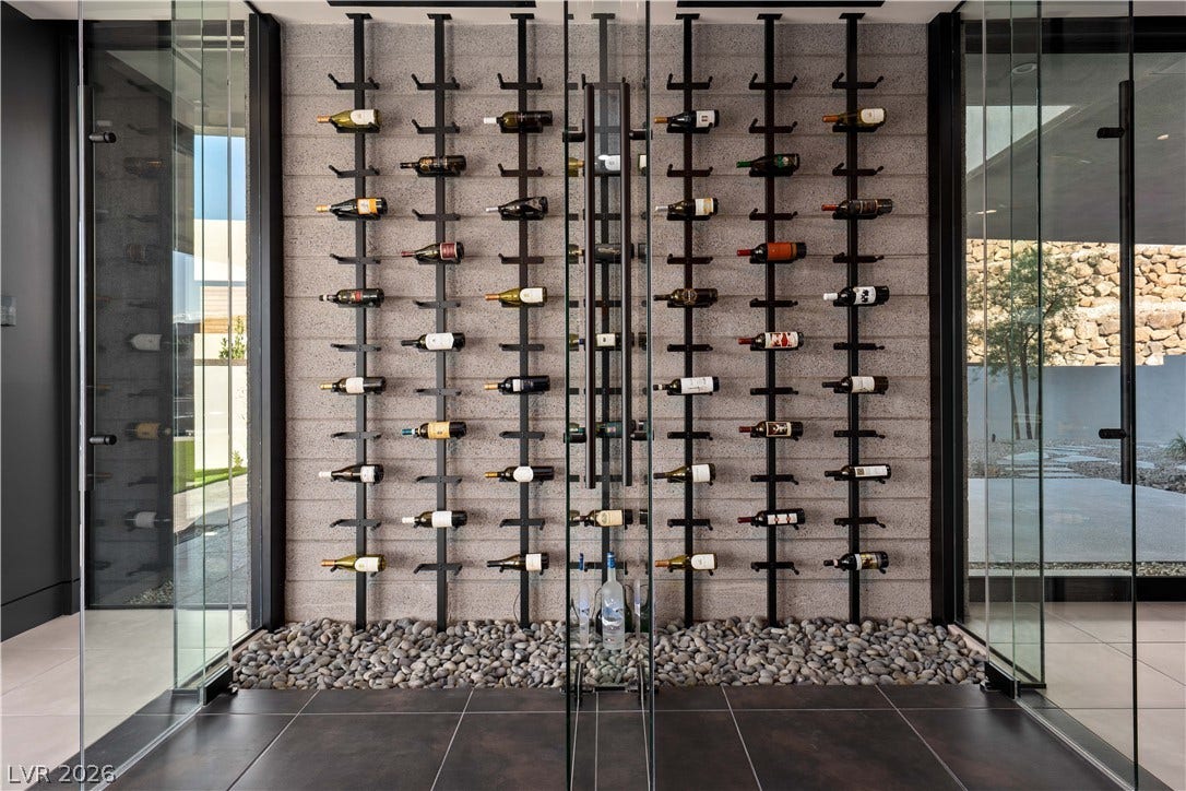25 Boulderback Drive, Henderson, NV 89012 Floor-to-ceiling glass doors enclose this custom wine display set against a textured stone wall.