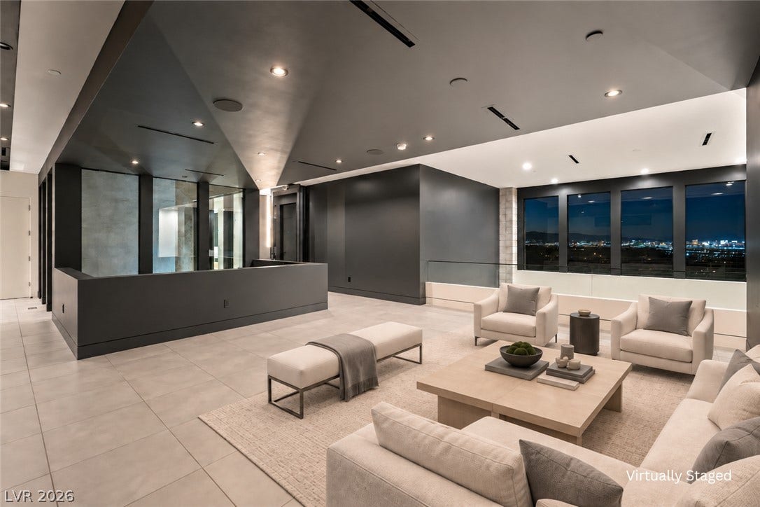 25 Boulderback Drive, Henderson, NV 89012 Dramatic vaulted ceilings and large windows highlight this expansive modern living space with city views.