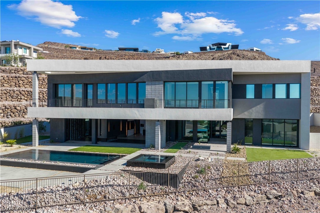 25 Boulderback Drive, Henderson, NV 89012 Striking contemporary architecture showcases clean geometric lines against a dramatic hillside setting.
