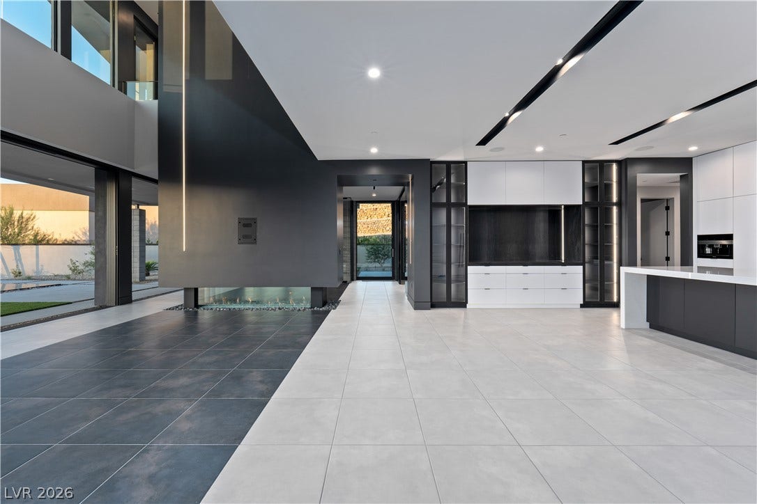 25 Boulderback Drive, Henderson, NV 89012 Clean architectural lines, large-format tile flooring, and a linear fireplace define this modern great room.