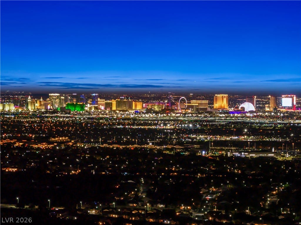 25 Boulderback Drive, Henderson, NV 89012 A glittering city skyline stretches across the horizon under a deep blue twilight sky.