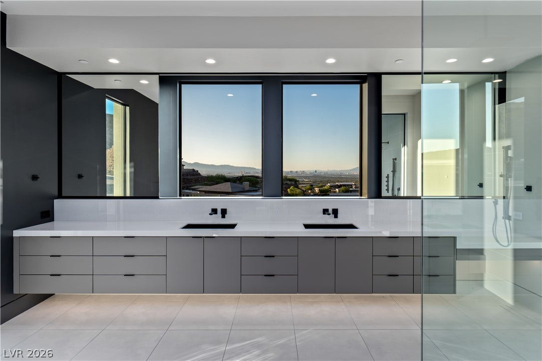 25 Boulderback Drive, Henderson, NV 89012 Panoramic mountain views highlight this sleek primary bathroom vanity with modern clean lines.