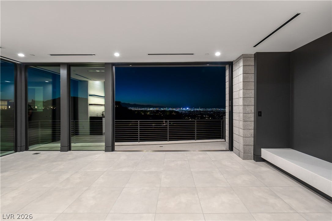 25 Boulderback Drive, Henderson, NV 89012 Massive sliding glass doors reveal a captivating city lights view from this modern tiled space.