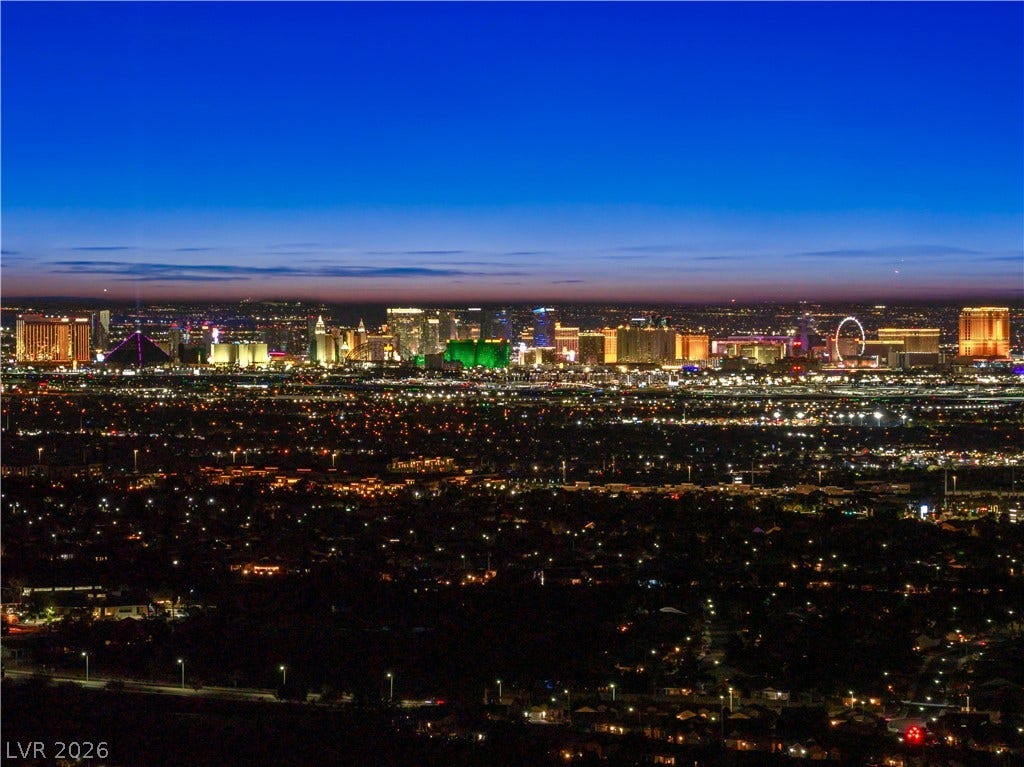 25 Boulderback Drive, Henderson, NV 89012 Glittering city lights define the panoramic evening view stretching across the horizon.