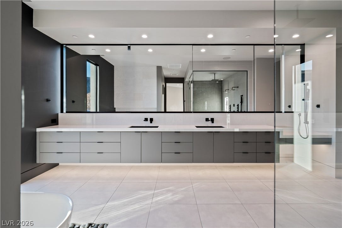 25 Boulderback Drive, Henderson, NV 89012 An expansive floating double vanity and a glass-enclosed shower anchor this contemporary bath space.