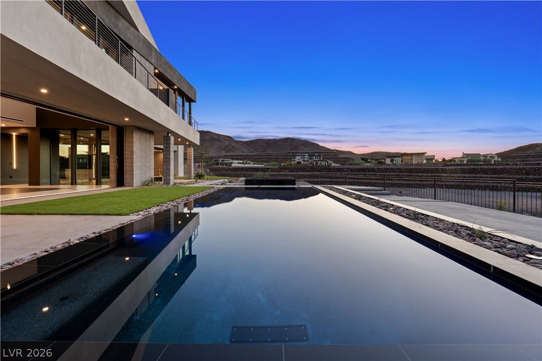 25 Boulderback Drive, Henderson, NV 89012 A sleek zero-edge pool anchors the backyard space against a majestic mountain backdrop.