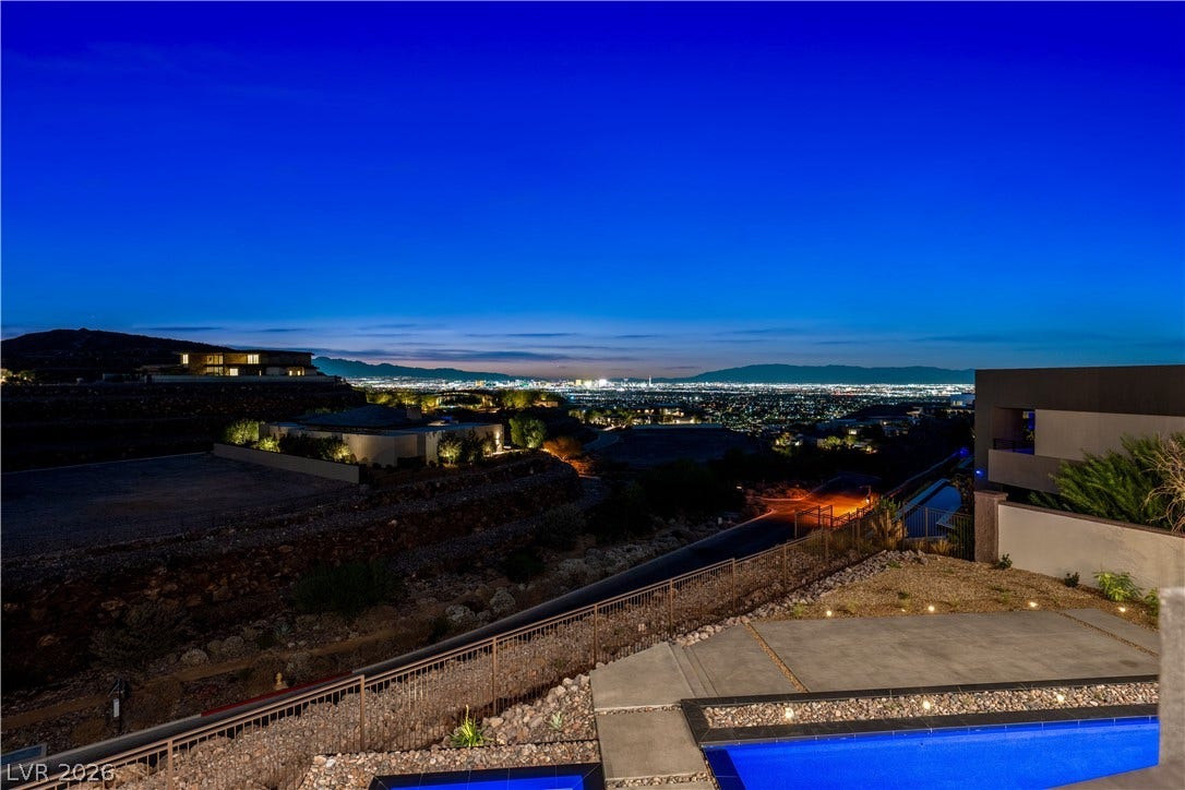 25 Boulderback Drive, Henderson, NV 89012 Glimmering city lights unfold across the horizon beyond an elevated outdoor terrace and pool.