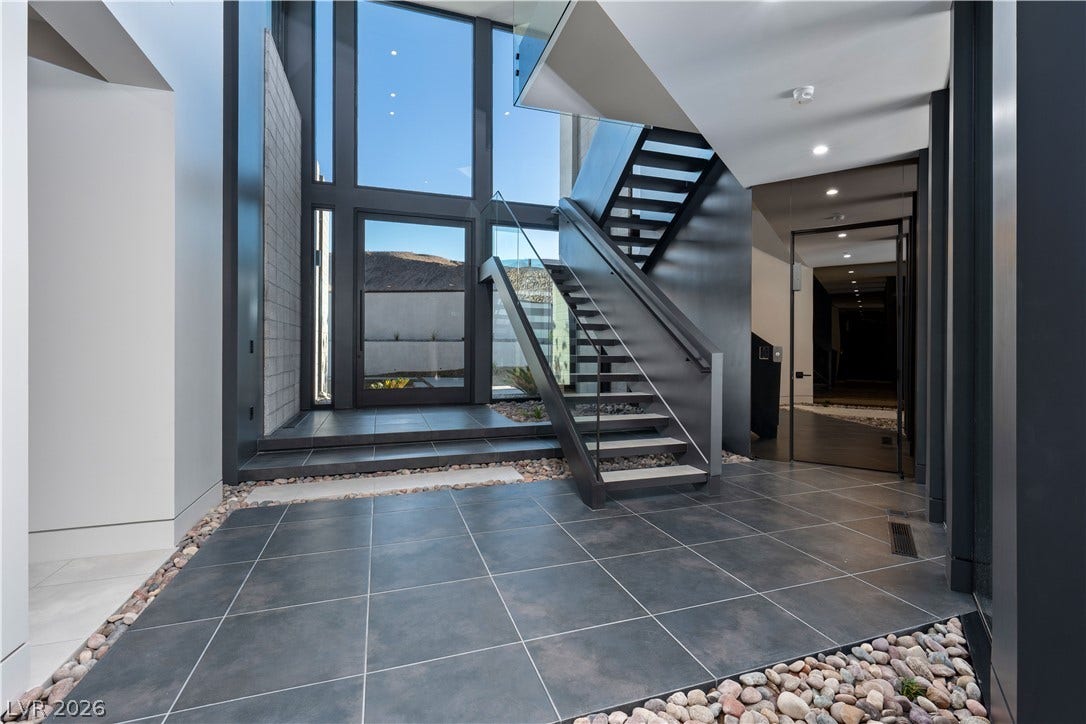 25 Boulderback Drive, Henderson, NV 89012 Soaring multi-story windows illuminate a contemporary foyer with sleek tile floors and architectural steel stairs.