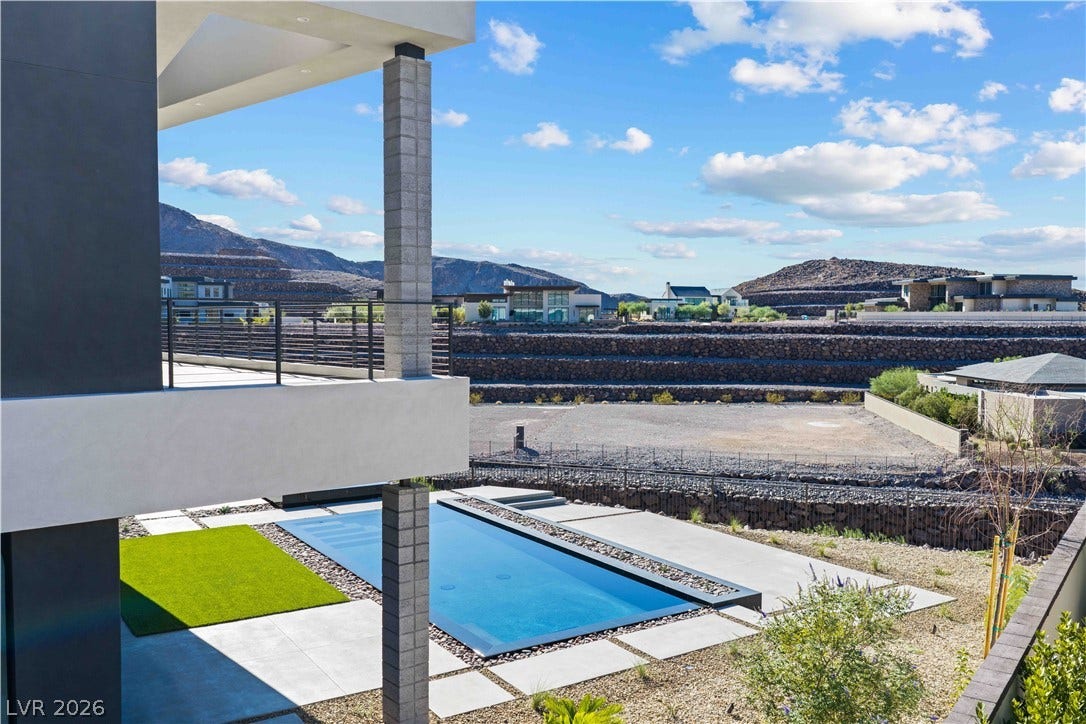 25 Boulderback Drive, Henderson, NV 89012 Panoramic mountain vistas frame the sleek outdoor pool and multi-level modern architecture.