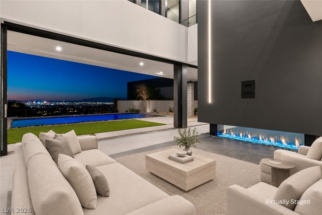 25 Boulderback Drive, Henderson, NV 89012 A modern fireplace anchors the living space, seamlessly opening to the pool and city lights.