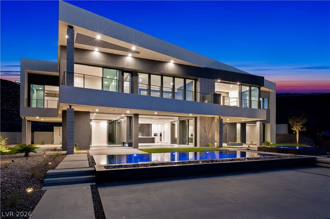 25 Boulderback Drive, Henderson, NV 89012 Dramatic modern architecture highlights the rear exterior alongside a sparkling pool at twilight.