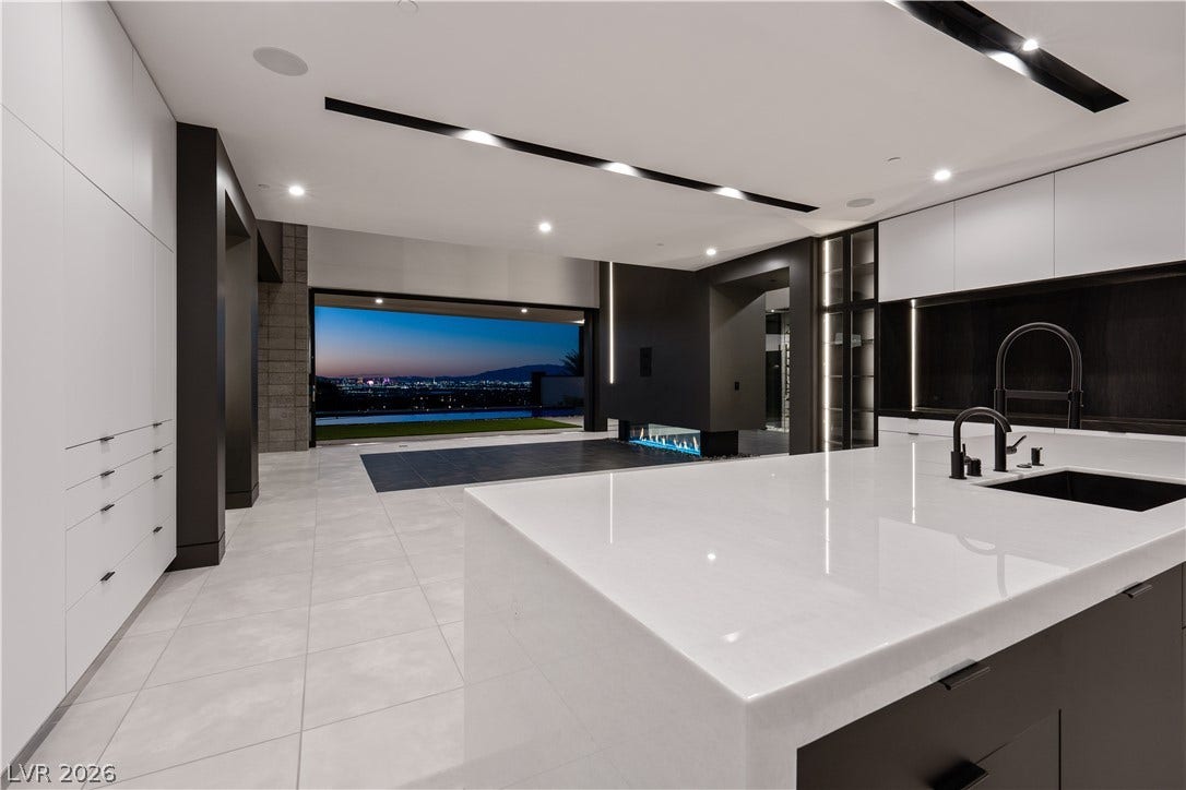 25 Boulderback Drive, Henderson, NV 89012 A sleek modern kitchen overlooks an open living area framed by expansive city views.