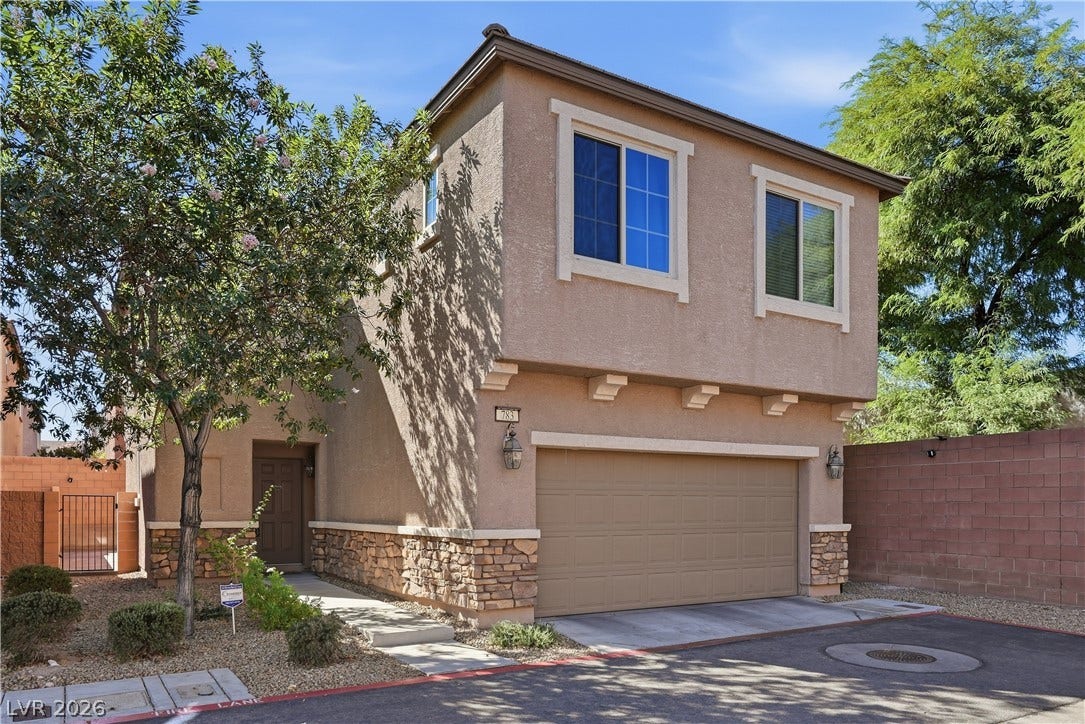 A charming two-story exterior features stucco walls, stone accents, and a spacious two-car garage.