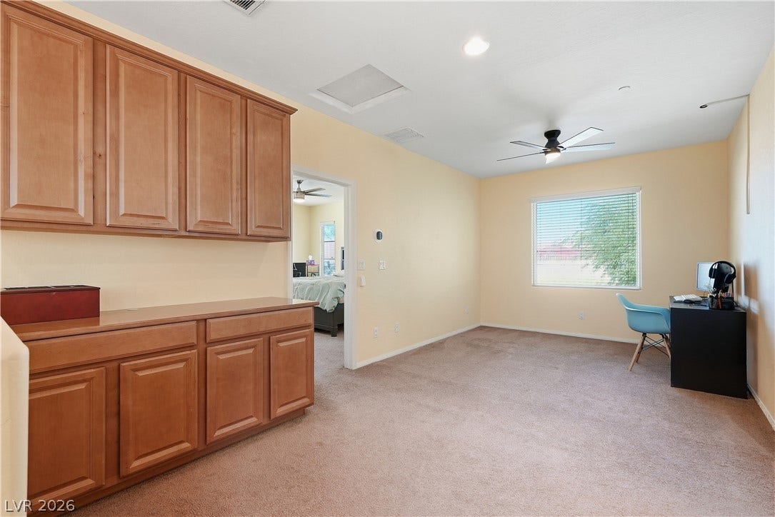 Generous built-in cabinetry and wall-to-wall carpeting define this versatile secondary living space.