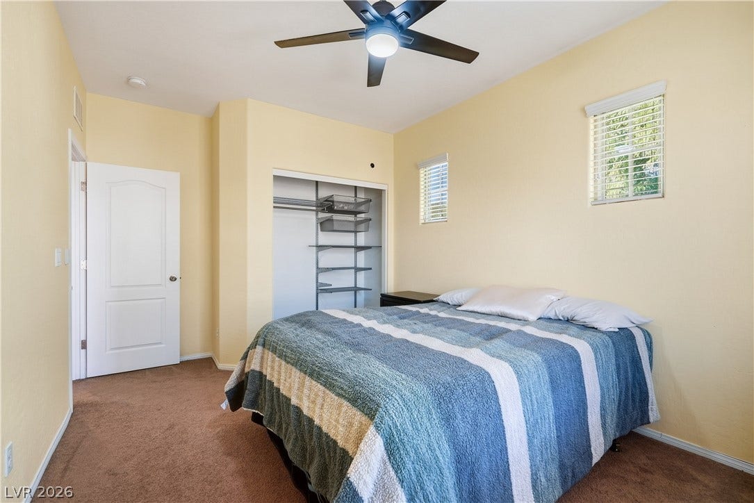 Plentiful natural light filters through small windows into this cozy bedroom with soft carpet flooring.