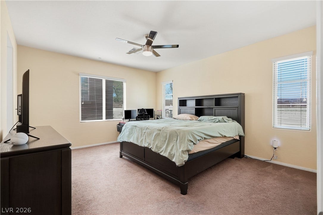 Soft wall tones complement the cozy carpeting in this relaxing bedroom space.
