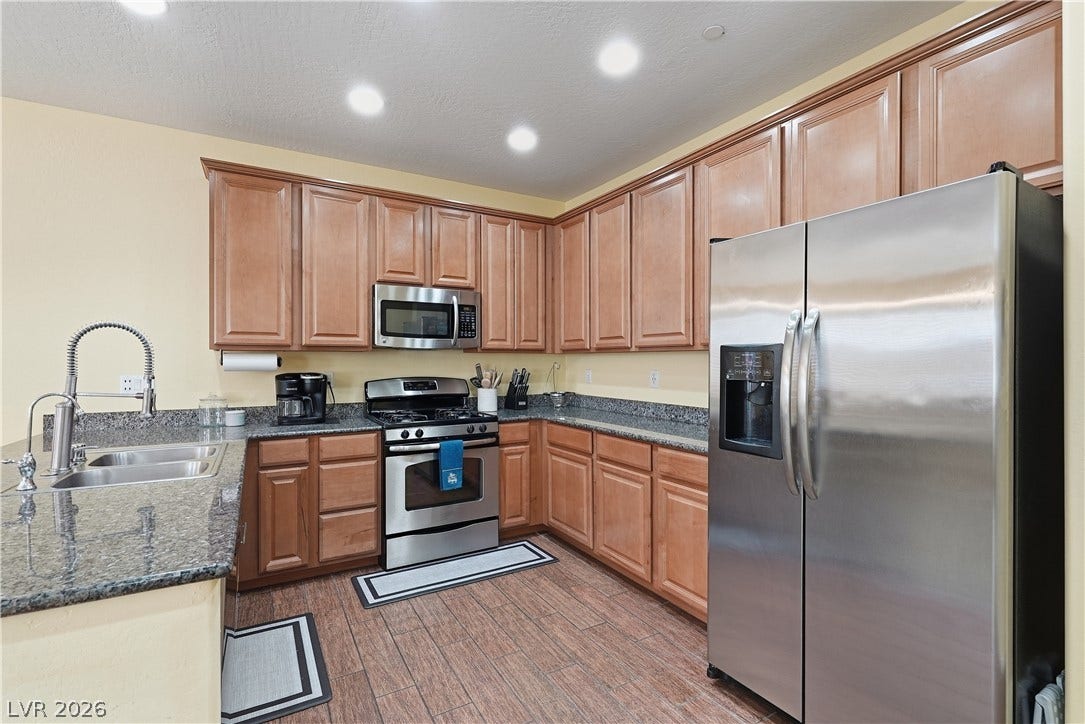 Gleaming stone countertops and classic wood cabinetry enrich this functional workspace.