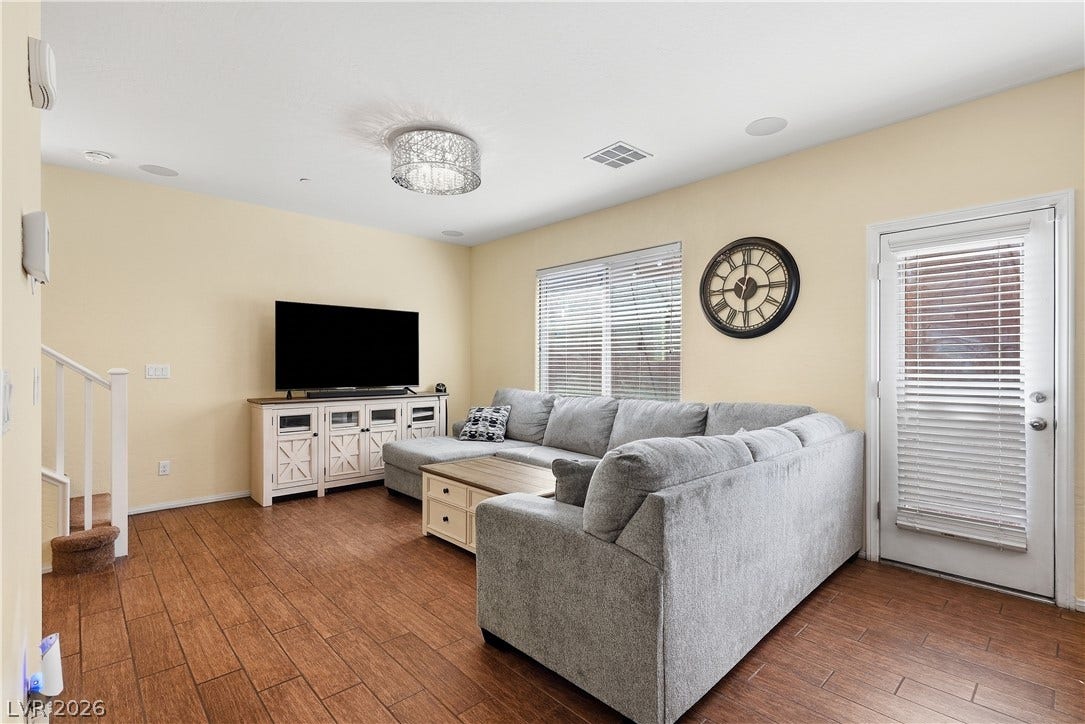 Gleaming wood-look tile floors and ample window light define this inviting gathering space.