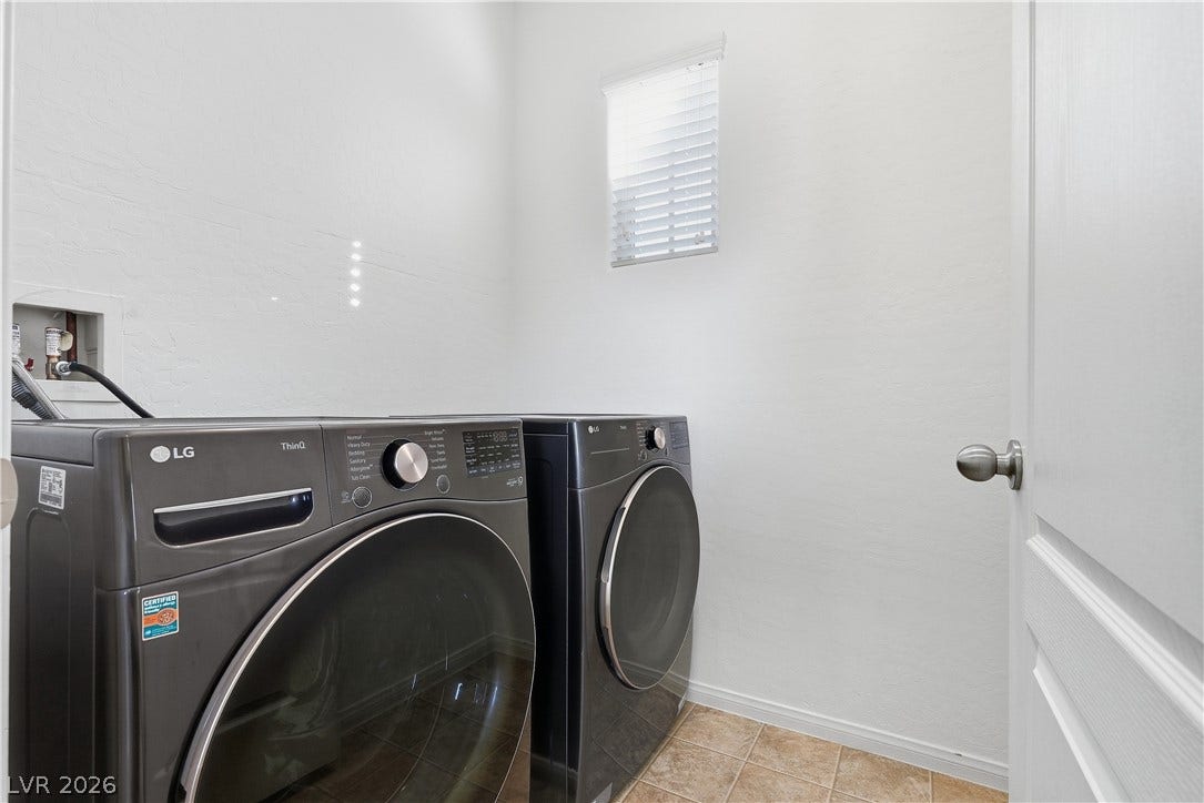 Tiled flooring and neutral walls define this functional dedicated laundry space.
