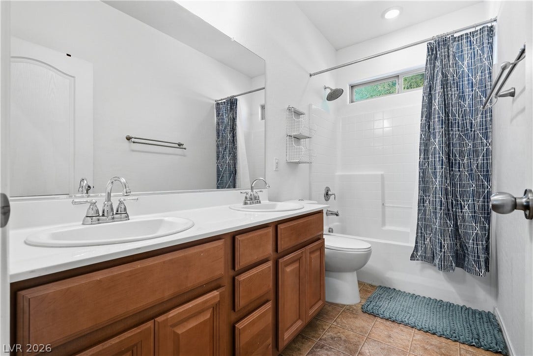 A spacious double vanity and tile flooring highlight this functional bathroom design.