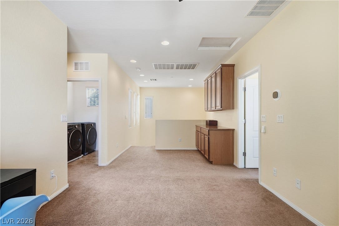 Plush carpeting and built-in cabinetry define this versatile upper-level landing space.