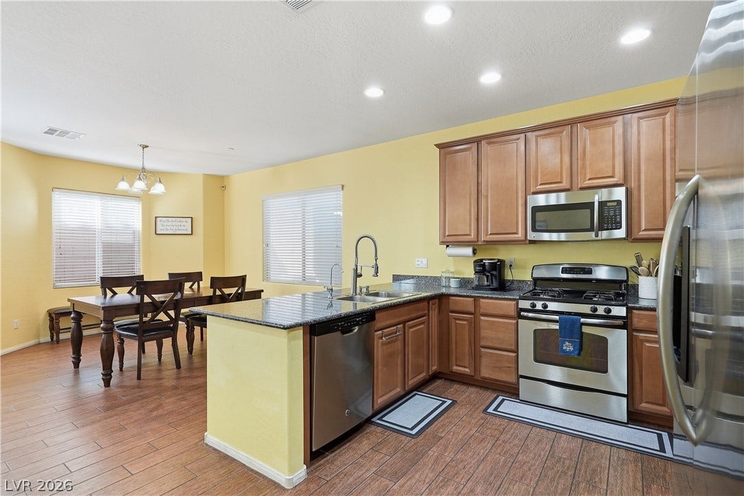 Gleaming stone countertops and classic wood cabinetry define this inviting kitchen and dining area.