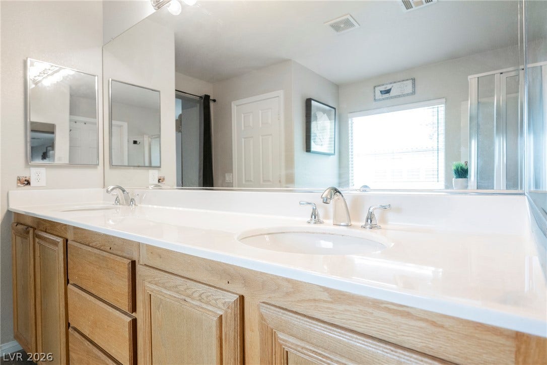 An expansive double vanity with oak cabinetry anchors this well-appointed bathroom space.