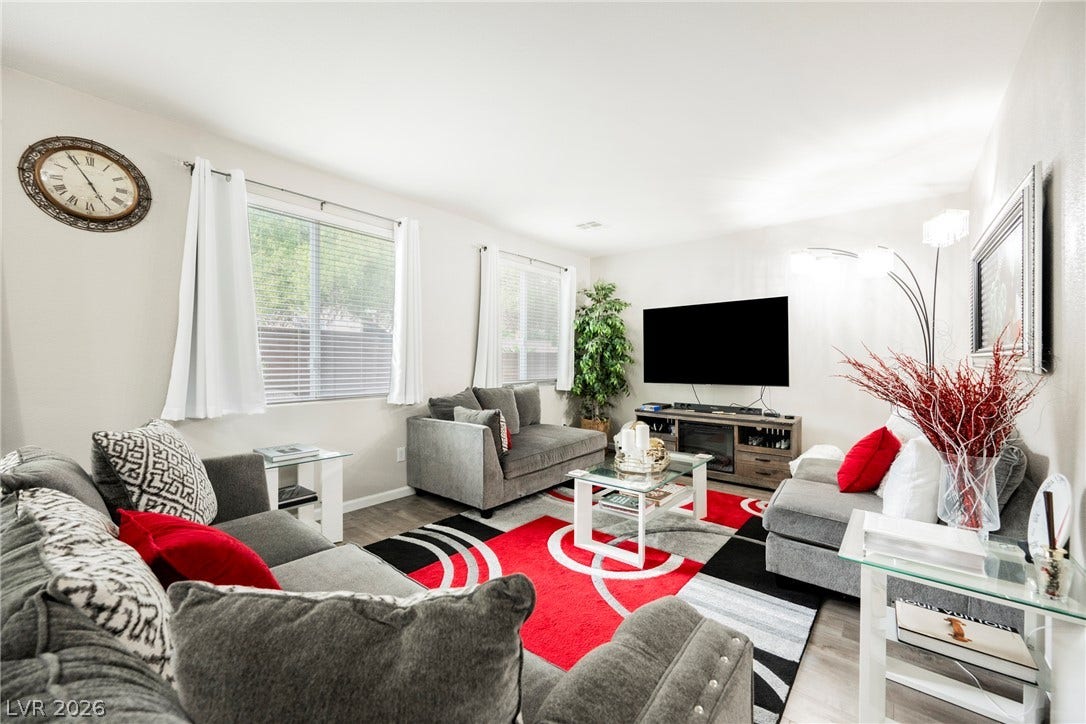 Natural light pours through dual windows onto modern flooring in this welcoming gathering space.
