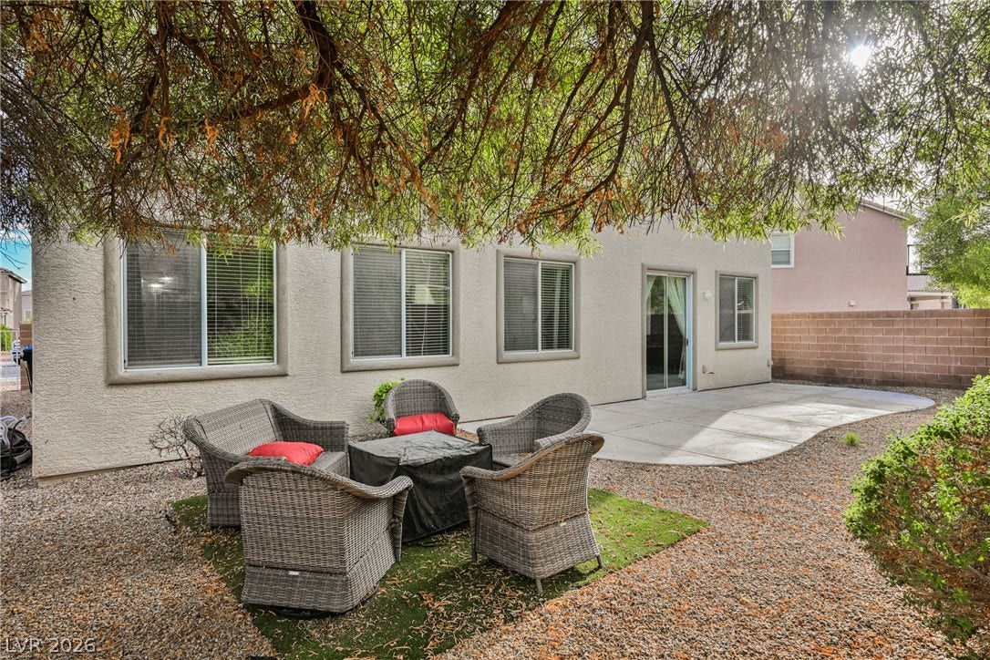 Mature trees shade a low-maintenance gravel yard complete with a concrete patio.