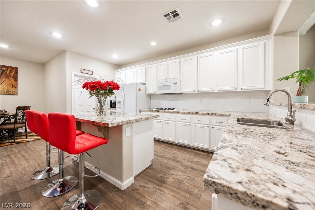 Rich granite countertops pair elegantly with classic white cabinetry in this functional layout.
