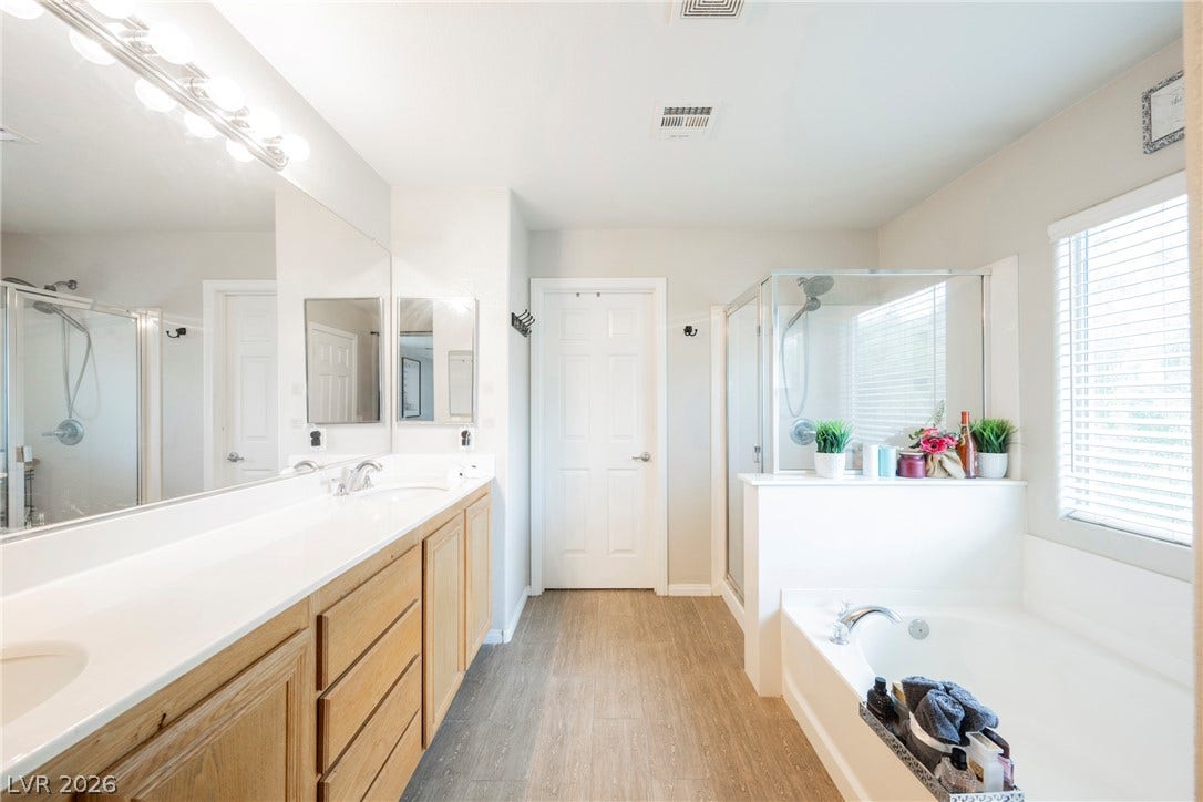 A spacious layout highlights the separate soaking tub and glass-enclosed shower.