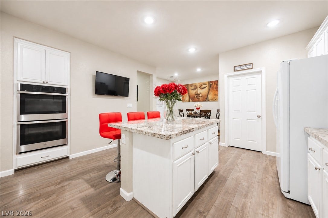 Gleaming stone countertops and wood flooring define this beautifully updated cooking space.