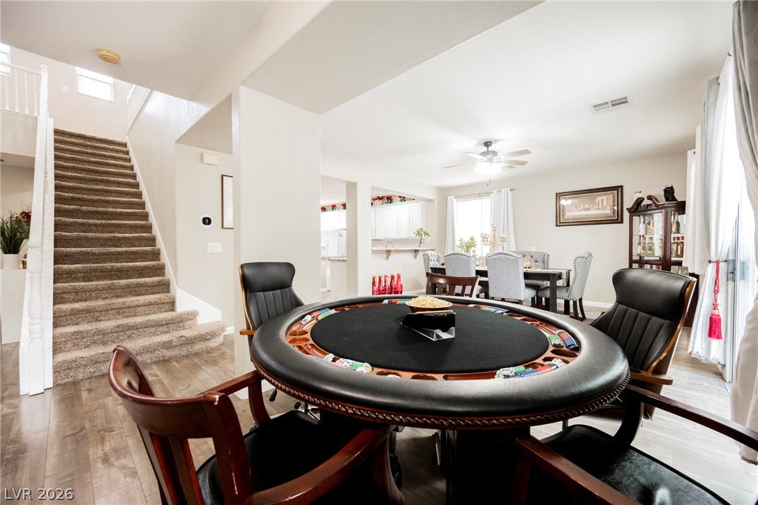 Gleaming wood-look floors flow past the staircase into a spacious open-concept living area.