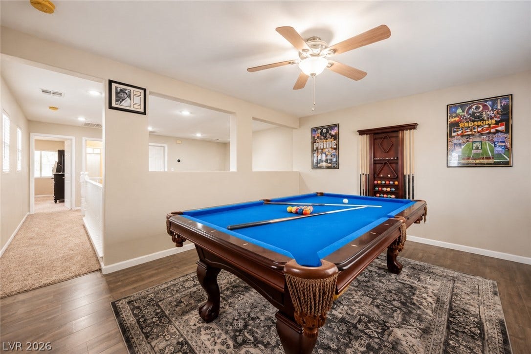 Smooth wood-style flooring and recessed lighting define this versatile upstairs recreation space.
