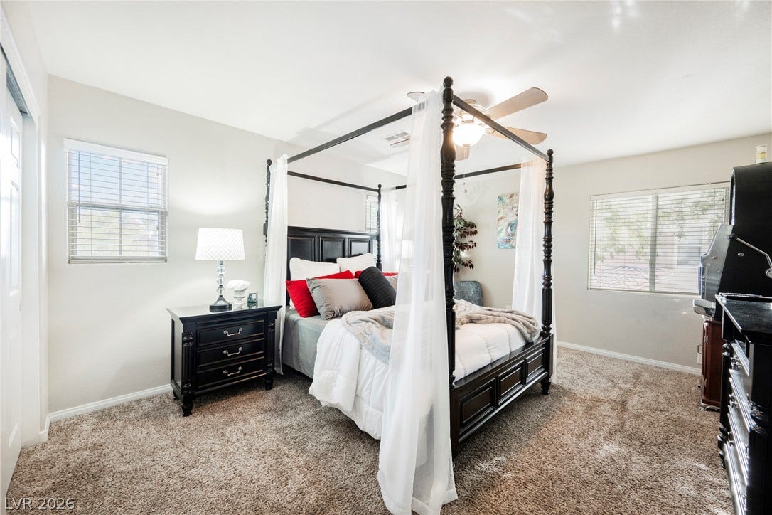 Natural light filters through multiple windows onto wall-to-wall carpeting in this restful retreat.