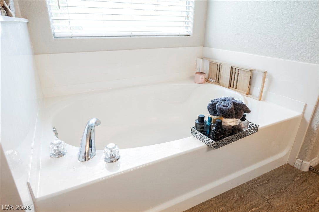 Natural light filters through the window above a deep soaking tub.