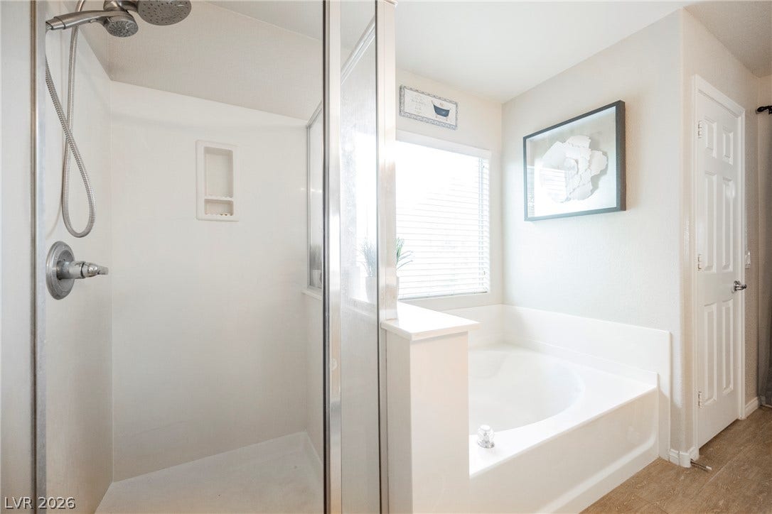 Relax in the deep soaking tub positioned next to a bright window and separate shower.