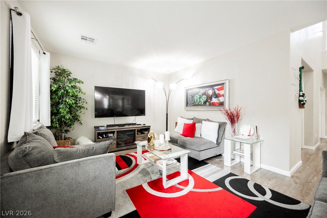 Smooth plaster walls and wood-look flooring establish a clean backdrop in this comfortable living area.