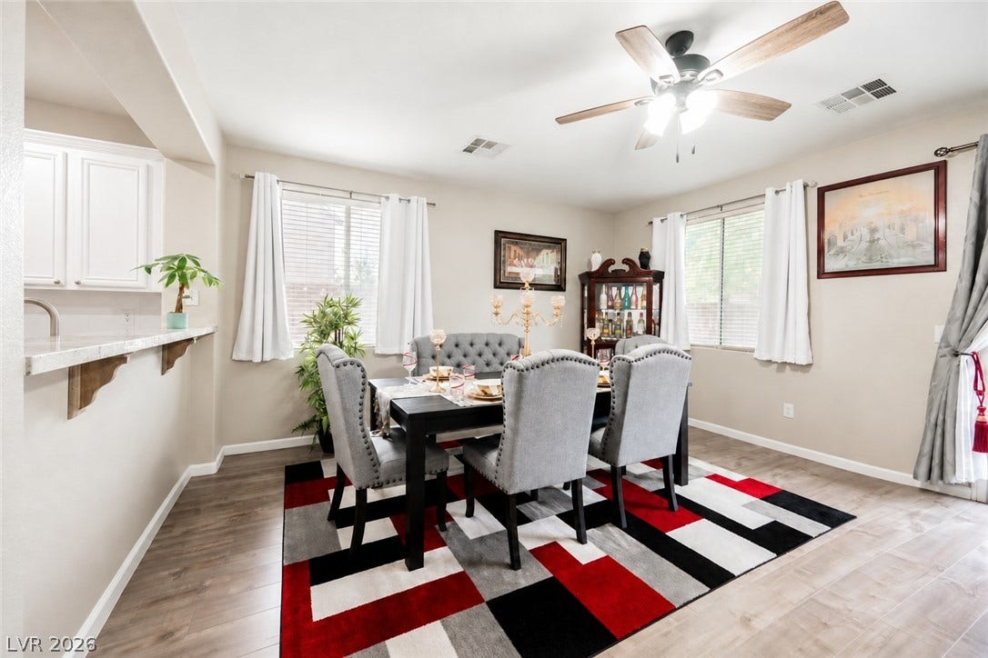Warm wood-look flooring and multiple windows enhance this inviting dining space.