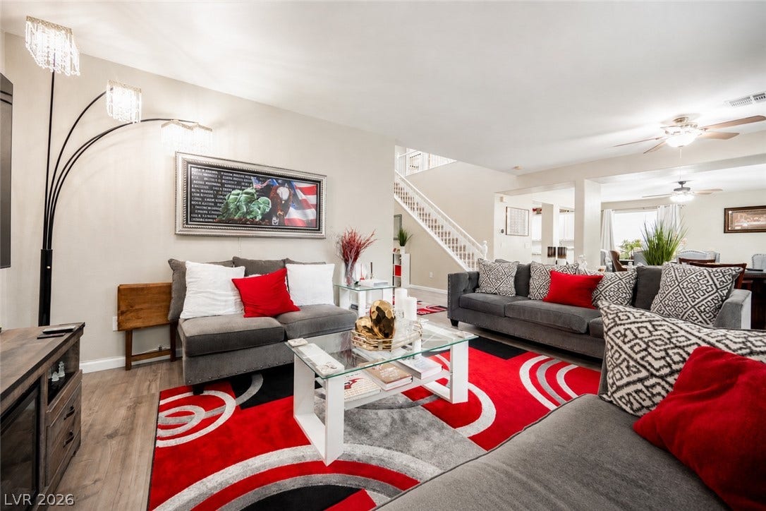Smooth plaster walls and rich wood floors flow into an open-concept living area with central stairs.