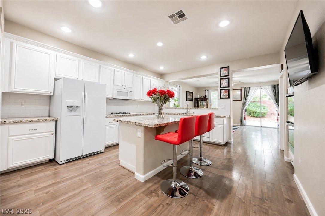 Gleaming wood floors connect the culinary workspace with an inviting adjacent living area.