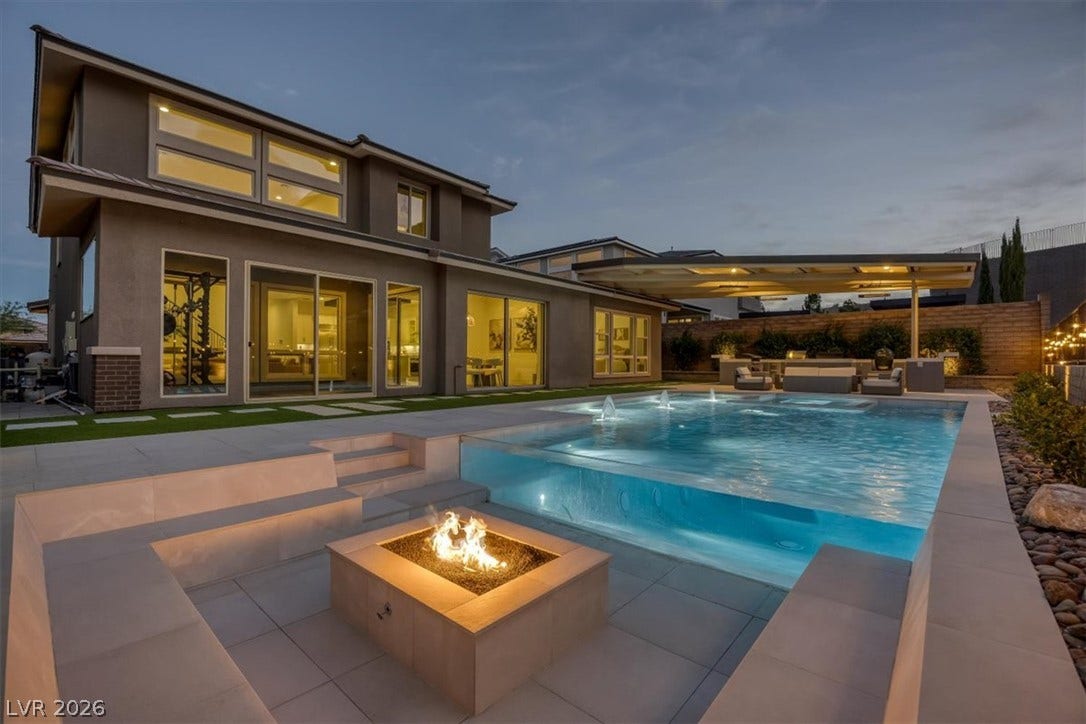 2611 Nevada Agave Lane, Las Vegas, NV 89138 An inviting fire pit sits adjacent to a modern pool featuring a glass wall.