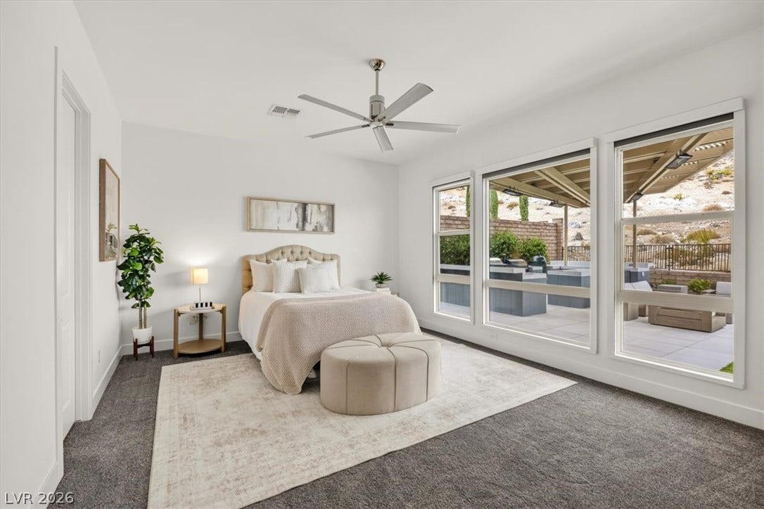2611 Nevada Agave Lane, Las Vegas, NV 89138 Large windows stream natural light across the plush carpeting in this serene bedroom space.