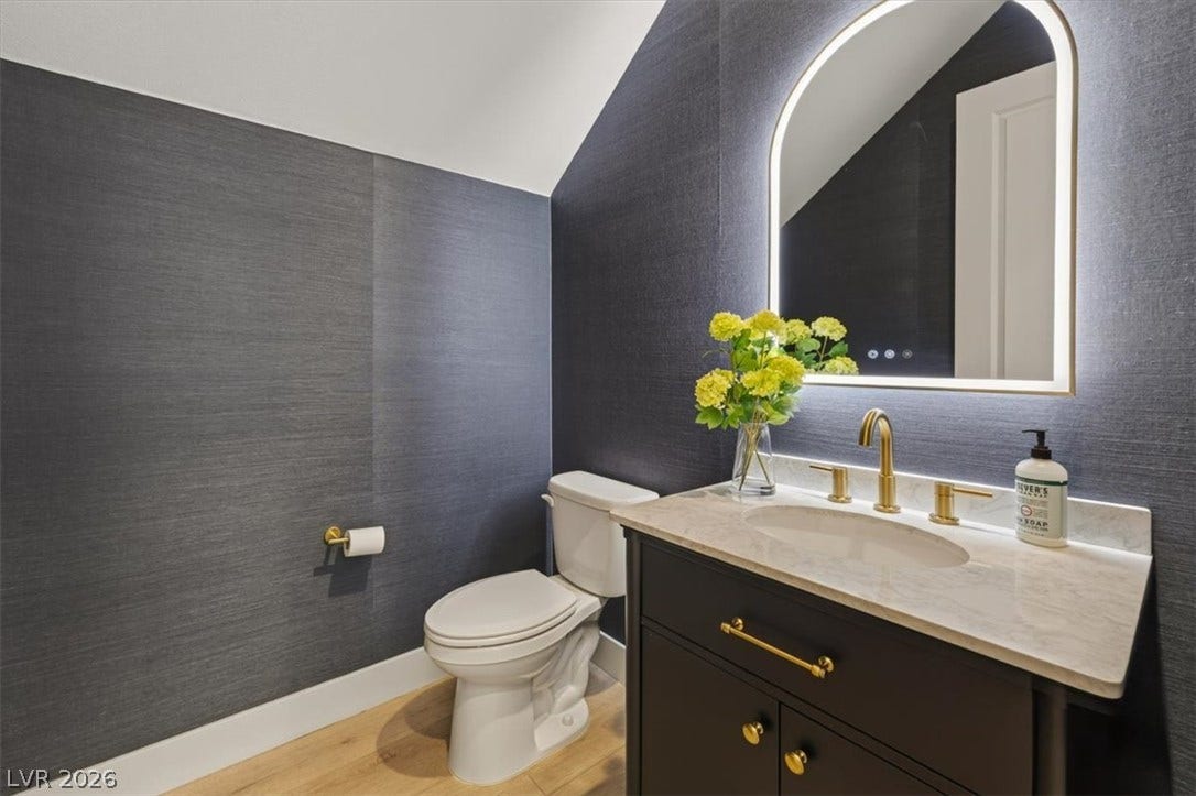 2611 Nevada Agave Lane, Las Vegas, NV 89138 A stylish powder room displays a single vanity with brass hardware and textured walls.