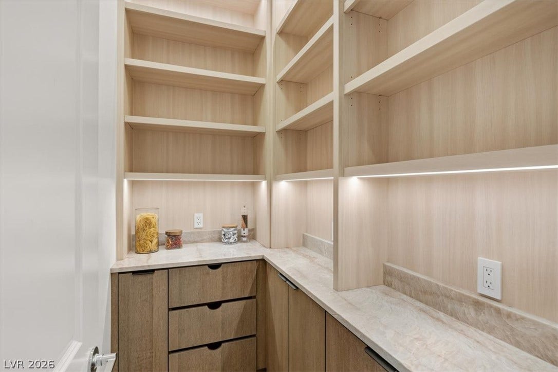 2611 Nevada Agave Lane, Las Vegas, NV 89138 Custom floor-to-ceiling shelving and stone counters optimize storage in this walk-in pantry.